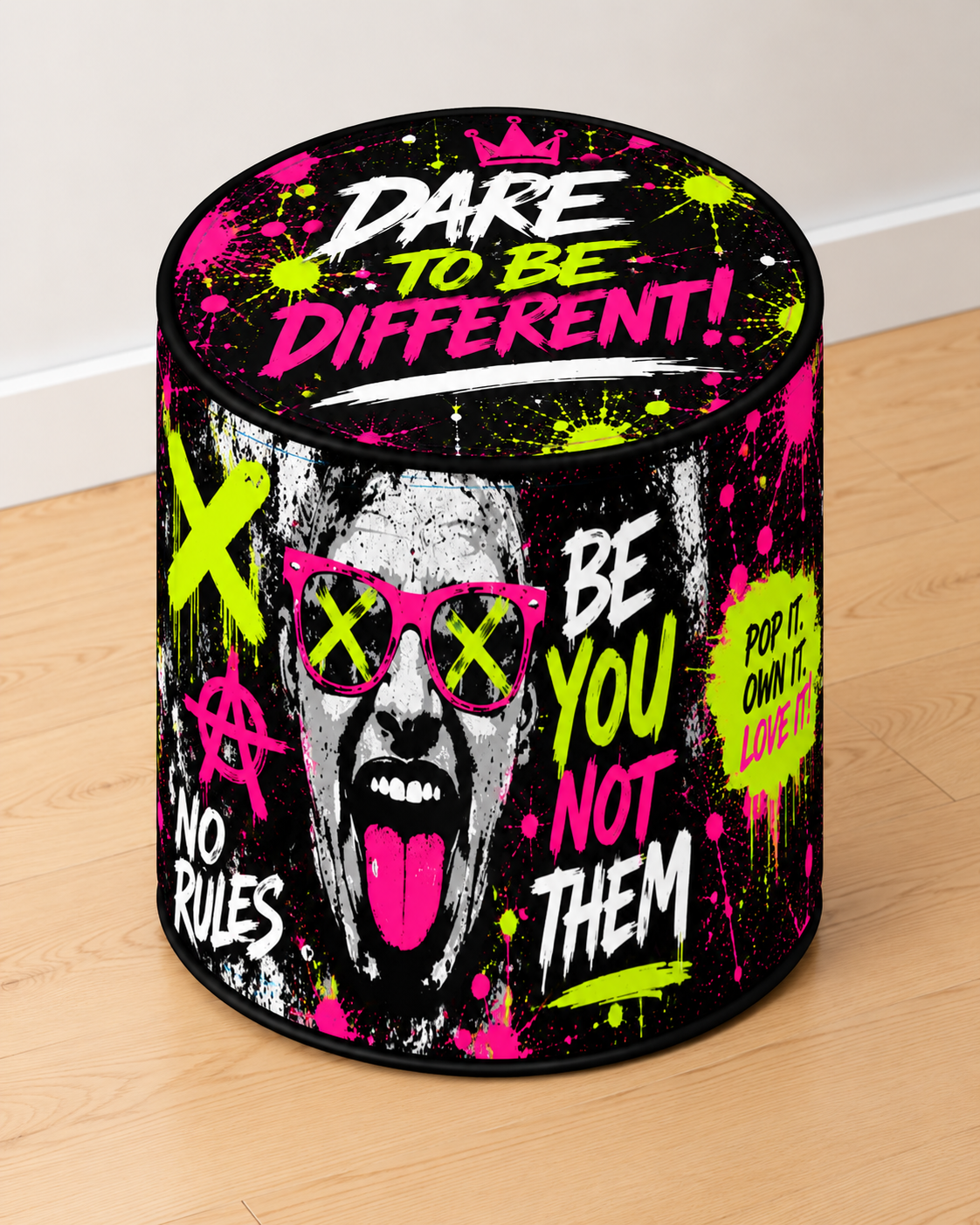 Dare to Be Different round printed ottoman featuring bold neon pink, green and black graffiti artwork with motivational lettering
